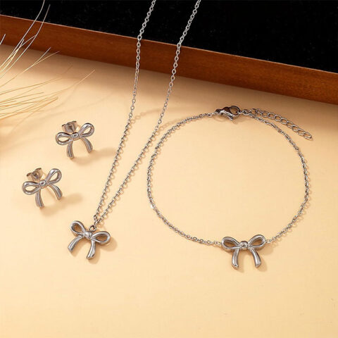 Set plateado aretes, pulsera y collar moñitas